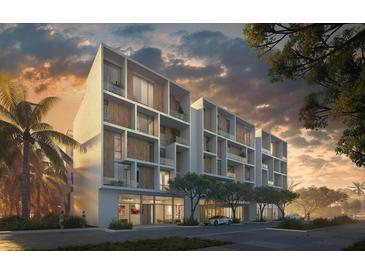 Modern condo building featuring sleek architectural design and lush landscaping at 430 Kumquat Ct # 408, Sarasota, FL 34236