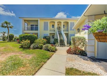 Charming two-story condo building featuring lush landscaping and classic architectural details, creating a welcoming curb appeal at 446 Cerromar Rd # 291, Venice, FL 34293
