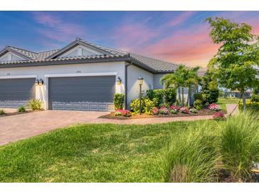 Charming single-story home features a well-manicured lawn, lush landscaping, and a paved walkway to the front entrance at 4750 Tortona Ct, Bradenton, FL 34211