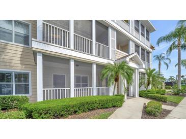 Inviting condo exterior featuring a screened porch with white railings and well-maintained landscaping at 4802 51St W St # 107, Bradenton, FL 34210