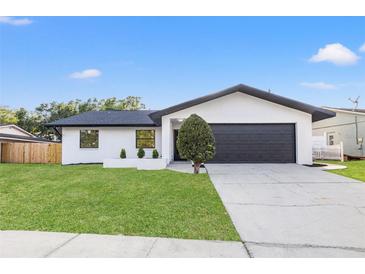 Charming single-Gathering home featuring a well-maintained lawn and sleek, modern design elements at 1052 Concord W Dr, Dunedin, FL 34698