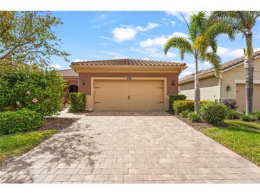 Charming single-story home featuring a paver driveway, a neutral palette and a well-maintained lawn at 11959 Tapestry Ln, Venice, FL 34293