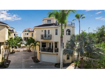 Beige three-story home featuring multiple balconies and a rooftop deck, surrounded by lush palm trees at 436 Canal Rd # A, Sarasota, FL 34242