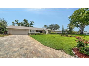 Charming single-story home featuring a well-manicured lawn and brick paved driveway at 4861 Waterbridge Down, Sarasota, FL 34235