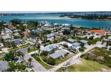 Stunning aerial view of coastal community with waterfront properties and lush tropical landscaping near the bay at 7030 Lois Ave, Longboat Key, FL 34228