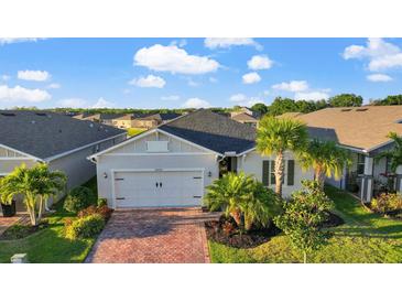 Charming single-story home with a two-car garage, beautiful landscaping, and a brick paved driveway at 14444 59Th E Cir, Bradenton, FL 34211