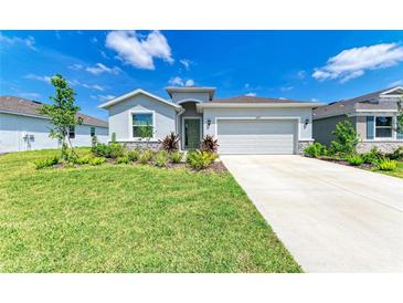 Well-maintained home featuring a landscaped front yard and concrete driveway leading to an attached garage at 16109 6Th E Ave, Bradenton, FL 34212