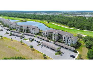 Scenic aerial view of condo community showcasing lush landscaping, a pristine lake, and a well-manicured golf course at 17510 Gawthrop Dr # 206, Bradenton, FL 34211