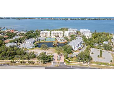 Breathtaking aerial view of a luxury residential complex with a pool, tennis courts, and bay access at 242 Hidden Bay Dr # 603, Osprey, FL 34229