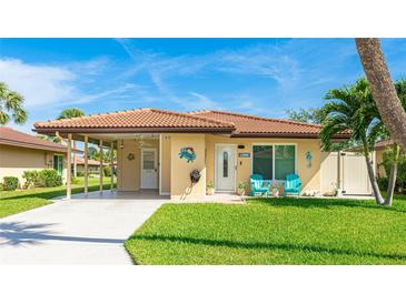 Charming home with a terracotta roof, a covered carport, and inviting blue Adirondack chairs on the front porch at 3213 Cambridge Ave, Bradenton, FL 34207
