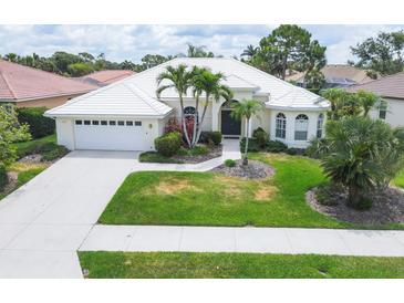 Beautiful single-story home features a white tile roof, two-car garage, and mature landscaping at 5106 Far Oak Cir, Sarasota, FL 34238