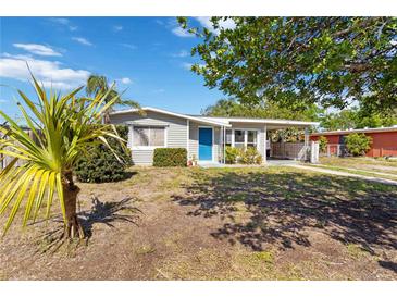 Charming single-story home with a bright blue door and carport offers a cozy curb appeal at 6720 Northampton Pl, Bradenton, FL 34207