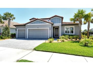 Beautiful single-Gathering home featuring a well-manicured lawn, three-car garage, and an eye-catching terra cotta tile roof at 6800 Dunlin Ct, Sarasota, FL 34241