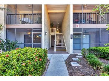Inviting condo exterior featuring a walkway, second-story porch, and lush landscaping at 752 White Pine Tree Rd # 101, Venice, FL 34285