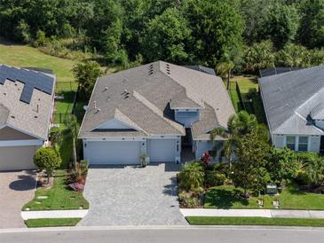 Beautiful aerial view of a well-maintained home with a three-car garage, lush landscaping, and a spacious layout at 11713 Goldenrod Ave, Bradenton, FL 34212