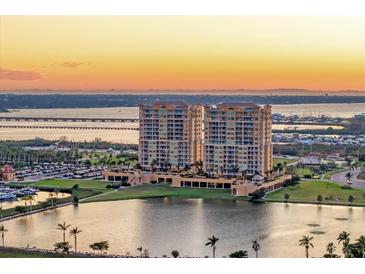 Stunning aerial view of waterfront condos, marina, and bay during sunset at 130 Riviera Dunes Way # 903, Palmetto, FL 34221