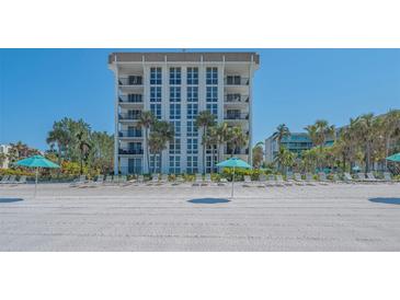 Stunning beachfront condo building featuring direct access to the sandy beach and lounge chairs with umbrellas at 1701 Gulf Of Mexico Dr # 502, Longboat Key, FL 34228