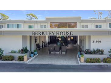 Berkley House exterior showcasing the entrance with a seating area and manicured landscaping at 21300 Brinson Ave # 214, Port Charlotte, FL 33952