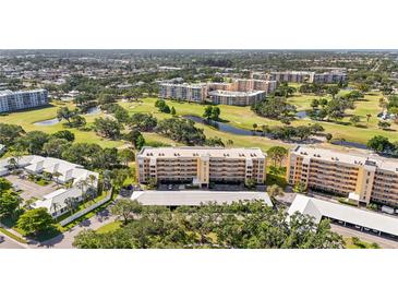 Scenic aerial view of the golf course community featuring lush greenery, ponds, and multi-story condo buildings at 3750 Pinebrook Cir # 104, Bradenton, FL 34209
