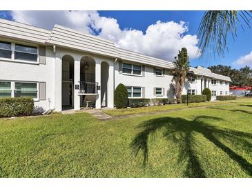 Well-maintained exterior of a two-story building with arched entryways and lush green lawn at 5800 Hollywood Blvd # 312, Sarasota, FL 34231