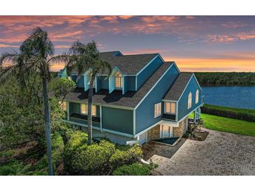Stunning waterfront home featuring a blue exterior, a new roof, a paver driveway, and lush landscaping at 12 Tidy Island Blvd, Bradenton, FL 34210