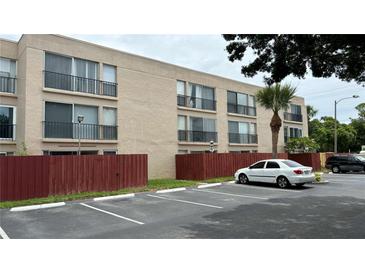 Exterior view of multi-Gathering condo with black wrought iron balconies and tan paint scheme at 2763 Woodgate Ln # 210, Sarasota, FL 34231