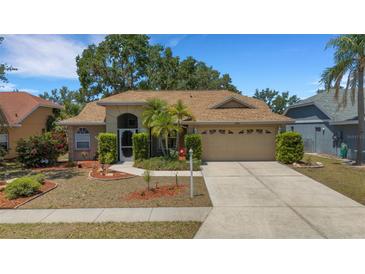 Charming single-story home with a well-manicured lawn, palm trees, and a two-car garage at 4926 72Nd E St, Bradenton, FL 34203
