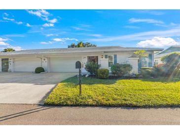 Charming single-story home with a well-manicured lawn and a two-car garage, nestled under a bright blue sky at 7311 7Th W Ave # 7311, Bradenton, FL 34209