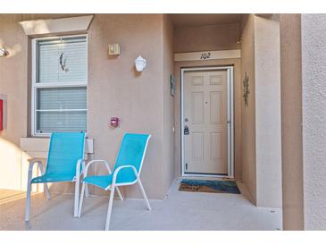 Inviting front porch featuring a pair of comfortable chairs, creating a relaxing and welcoming entrance to the condo at 803 Fairwaycove Ln # 102, Bradenton, FL 34212