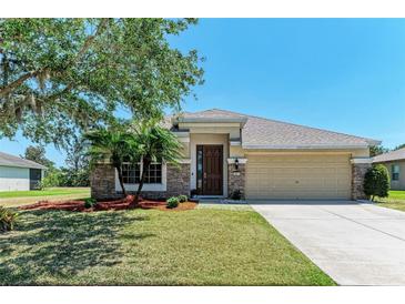 Charming single-story home featuring stone accents, manicured lawn, and a two-car garage at 9819 46Th E Ct, Parrish, FL 34219