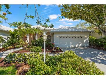 Charming single Gathering home with lush landscaping and a well-manicured lawn on a sunny day at 4180 Via Mirada, Sarasota, FL 34238