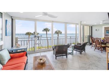 Bright living room featuring floor to ceiling windows with ocean views and access to the balcony at 6470 Mourning Dove Dr # 201, Bradenton, FL 34210