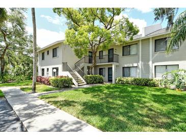Inviting two-story condo building featuring lush landscaping and a well-maintained lawn at 7876 Eagle Creek Dr, Sarasota, FL 34243