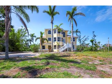 Stunning multi-level home with ample windows, white stairs, and surrounded by lush tropical landscaping at 9315 9Th Nw Ave, Bradenton, FL 34209
