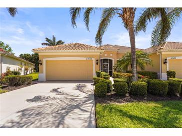 Charming single-story home with a well-manicured lawn, mature landscaping, and a two-car garage at 27243 Ipswich Dr, Englewood, FL 34223
