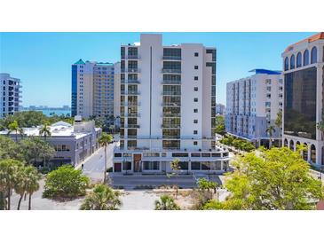 Modern, white high-rise condo building featuring balconies and floor-to-ceiling windows at 300 S Pineapple Ave # 302, Sarasota, FL 34236