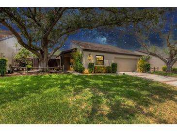 Charming single-story home with a lush front lawn and mature trees providing shade at 3955 Glen Oaks Manor Dr, Sarasota, FL 34232