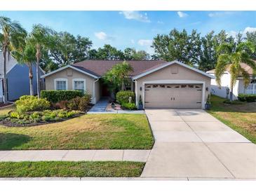 Charming single-story home with a manicured lawn, two-car garage and mature landscaping at 4211 Kingsfield Dr, Parrish, FL 34219