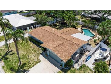 An aerial view of a single Gathering house with a brown roof, pool and a boat parked on the side of the property at 5705 9Th Ave Dr W, Bradenton, FL 34209