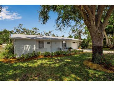 Charming single-story home with a well-manicured lawn and a cozy front porch seating area at 709 84Th Nw St, Bradenton, FL 34209