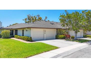 Charming home featuring a two-car garage, well-manicured lawn, and lush landscaping at 7374 Royal Birkdale Dr # 15D, Sarasota, FL 34238