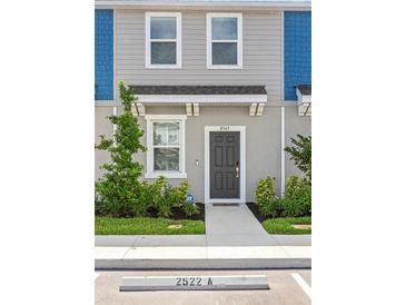 Charming townhome featuring a modern gray front door and nicely landscaped walkway at 8545 Daybreak St, Sarasota, FL 34241