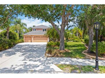 Charming two-story home with a three-car garage and a well-manicured lawn in a lush, green setting at 9915 Old Hyde Park Pl, Bradenton, FL 34202