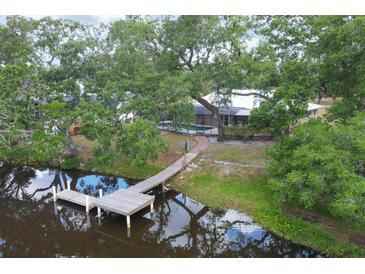 Stunning backyard view featuring a private dock, serene water, and lush green trees at 1130 Mill Creek Rd, Bradenton, FL 34212