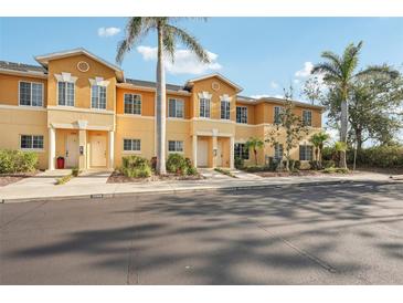 Inviting two-story townhomes with tropical landscaping and sunny yellow exterior at 12358 Destiny Dr, Venice, FL 34292