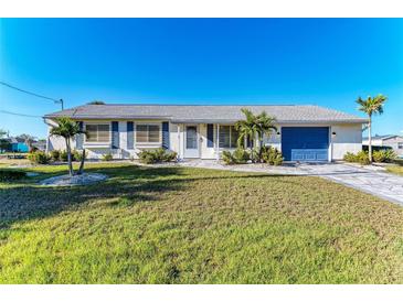Charming single-story home with manicured lawn, blue shutters, and a matching blue garage door at 18082 Eau Gallie S Cir, Port Charlotte, FL 33948