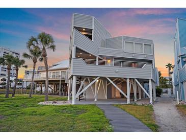 Stunning beach house featuring an elevated design, multiple decks, a spiral staircase, and lush landscaping at 216 Tenacity Ln, Sarasota, FL 34242