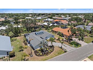 Beautiful aerial view of a modern home with a circular driveway, well-manicured landscaping, and a gray roof at 238 Lookout Point Dr, Osprey, FL 34229