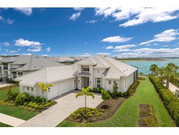 Stunning exterior elevation with manicured lawn, beautiful landscaping, and a large three-car garage at 508 Blue Shell Loop, Sarasota, FL 34240