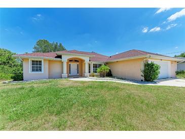 Charming single-story home featuring a well-manicured lawn, red roof, and inviting front entrance at 5168 Cillette Ave, North Port, FL 34288